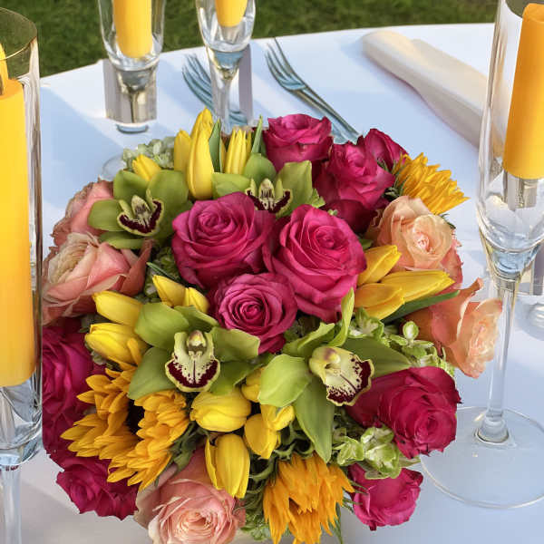 Bright mixed bouquet with pink roses, yellow tulips, and green orchids
