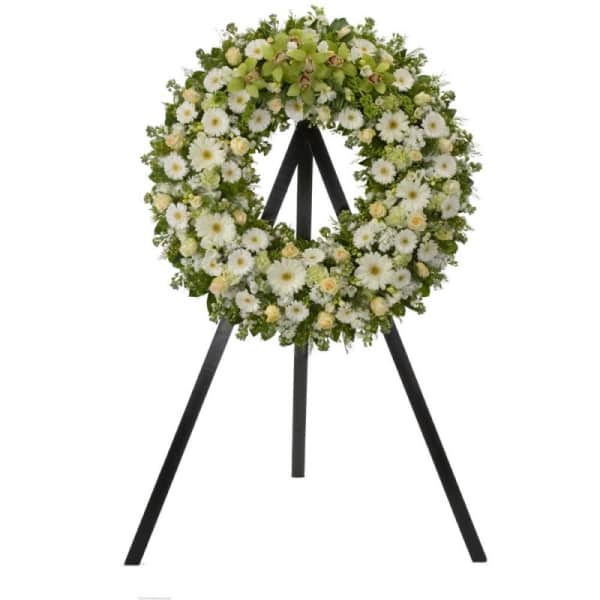 White and pale green floral wreath on a black easel