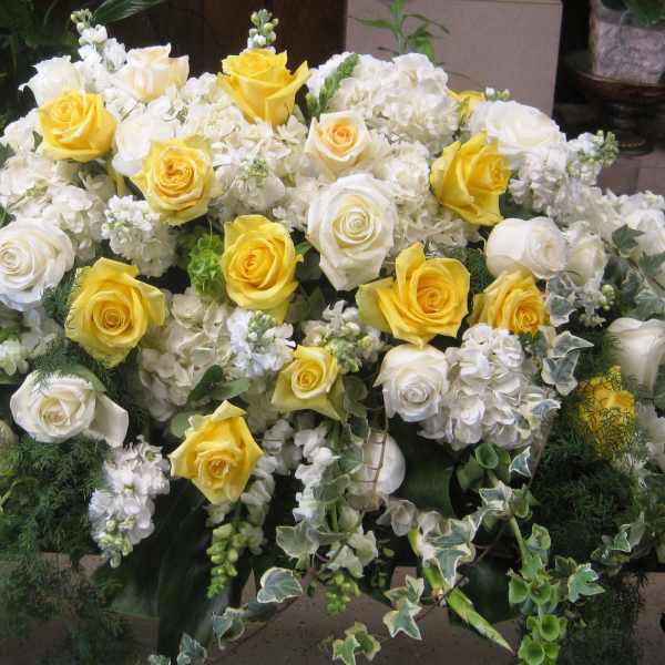 Large white and yellow rose arrangement on a table