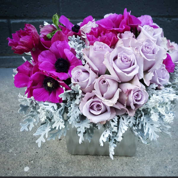 Lavender roses and magenta anemones in a square vase