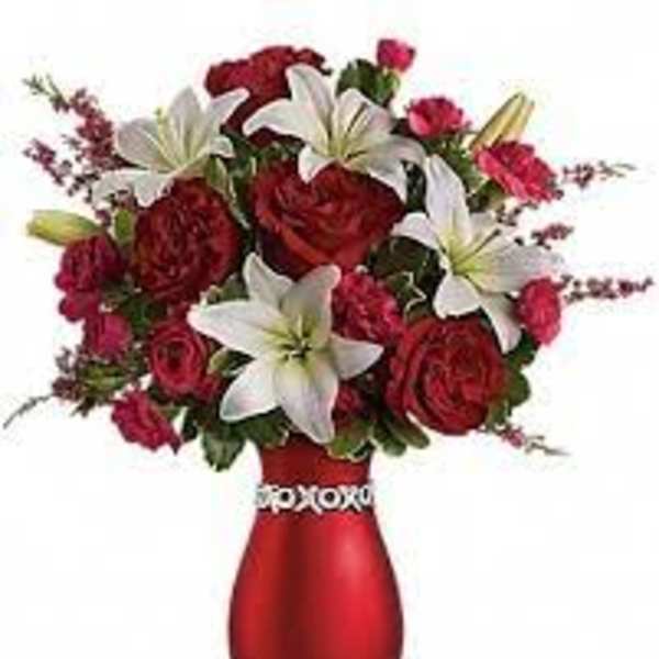 Red and white flower arrangement in a red vase