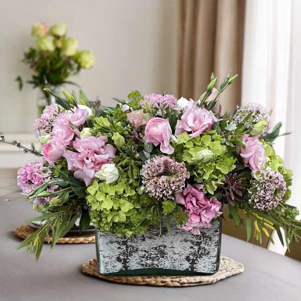 Pink and green floral arrangement in a rectangular vase