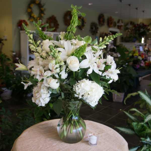 White floral arrangement in a glass vase on a table