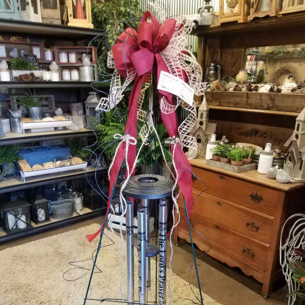 Tall memorial wind chime with a large pink ribbon bow