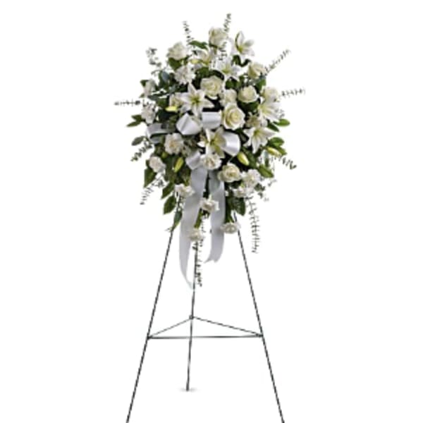 White floral standing spray on an easel with ribbon