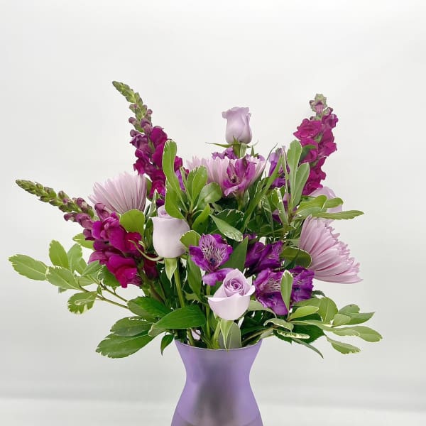 Lavender and magenta bouquet in a purple vase