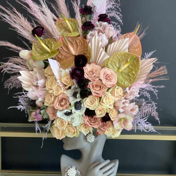 Large floral headpiece with roses and anthuriums on a mannequin bust