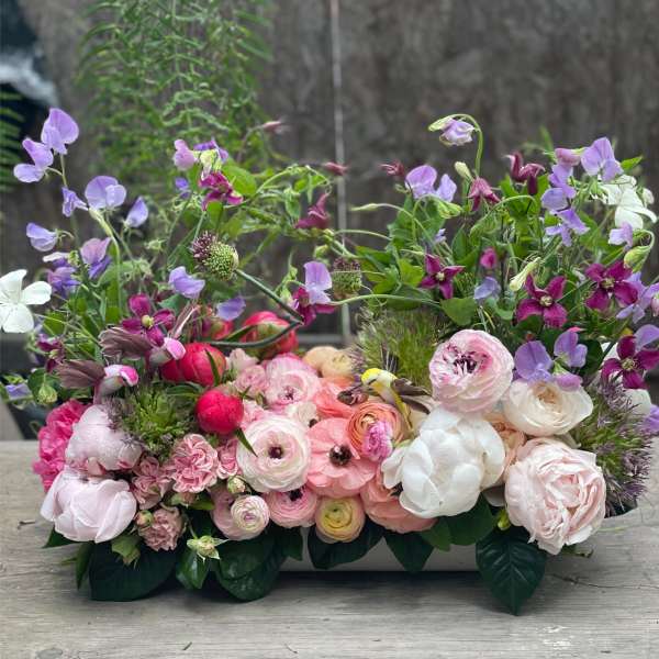 Low floral arrangement with pink, white, and purple blooms