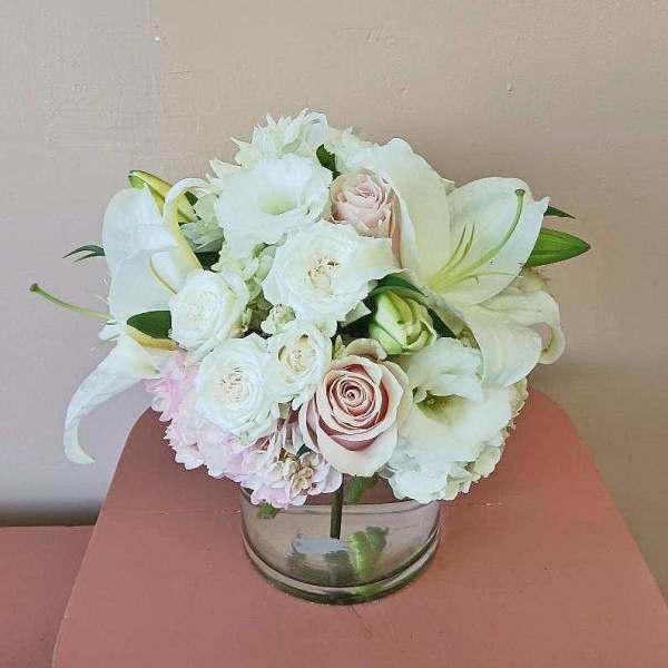 White and blush bouquet in a clear glass vase