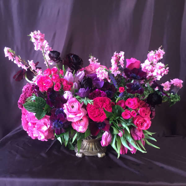 Large pink and purple floral arrangement in a decorative vase
