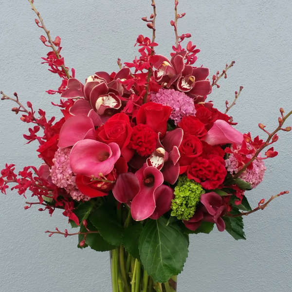 Red and pink floral arrangement in a clear glass vase