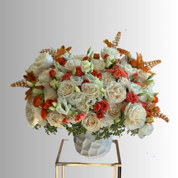 Large bouquet of white and coral roses in a textured white vase