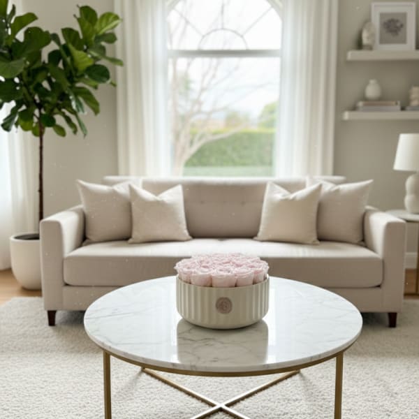 Round box of pale pink roses on a coffee table in a living room