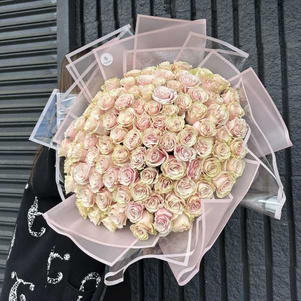 Large bouquet of pale pink roses wrapped in pink paper
