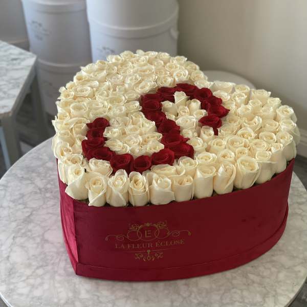 Heart-shaped box filled with white and red roses