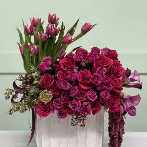 Pink roses and tulips arranged in a white vase