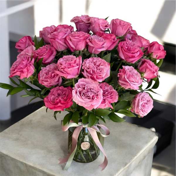 Bouquet of pink roses in a clear glass vase with a ribbon