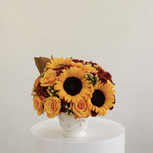 Bouquet of yellow sunflowers and roses in a white vase