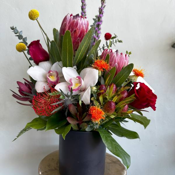 Mixed bouquet in a black vase with pink, white, and red blooms