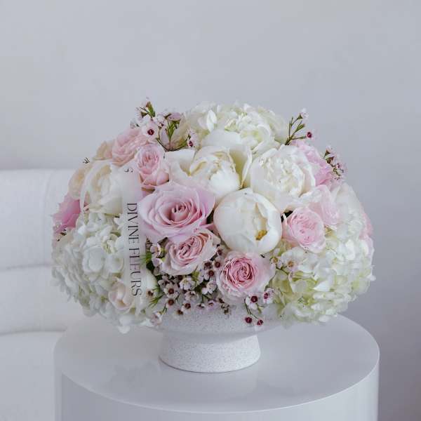 Round bouquet of pink and white flowers in a white vase