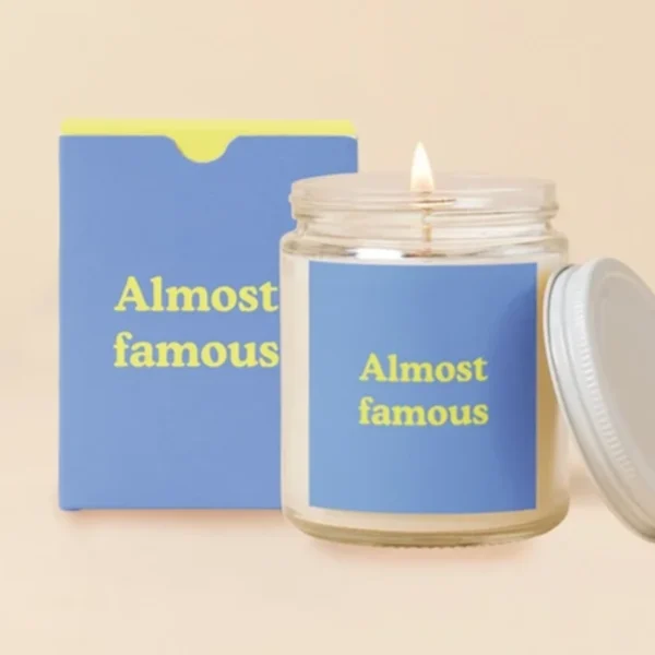 Lit candle in a glass jar with a matching box