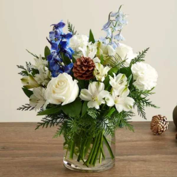 White and blue floral arrangement in a clear glass vase