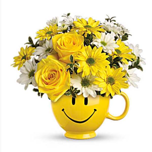 Yellow roses and daisies in a smiley-face mug