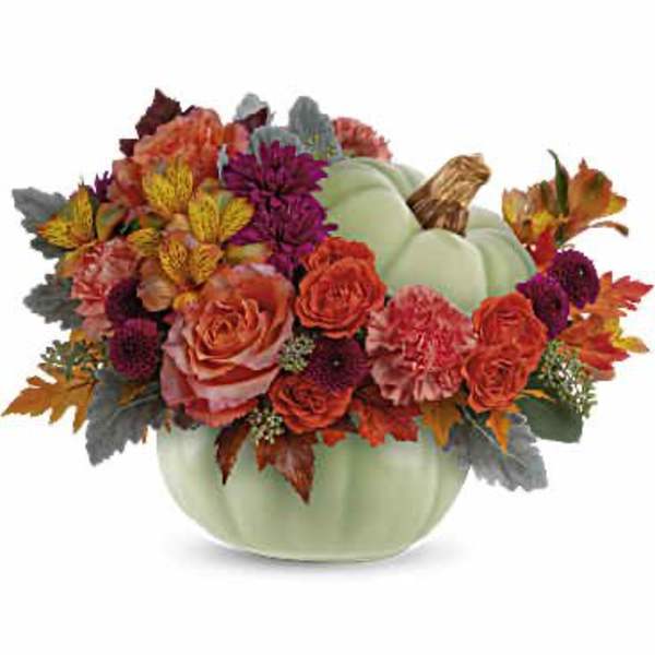 Autumn floral arrangement in a pale green pumpkin vase
