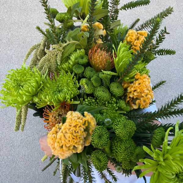 Large bouquet of green and yellow flowers with long fern-like foliage