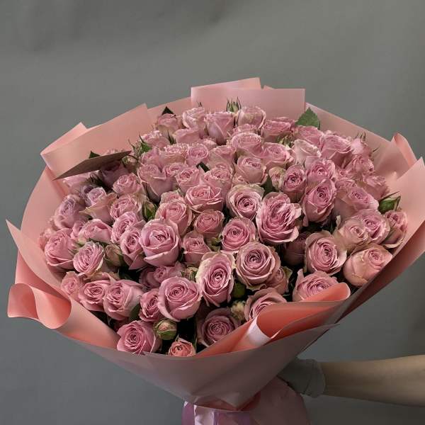 Large bouquet of pink roses wrapped in pink paper with ribbon
