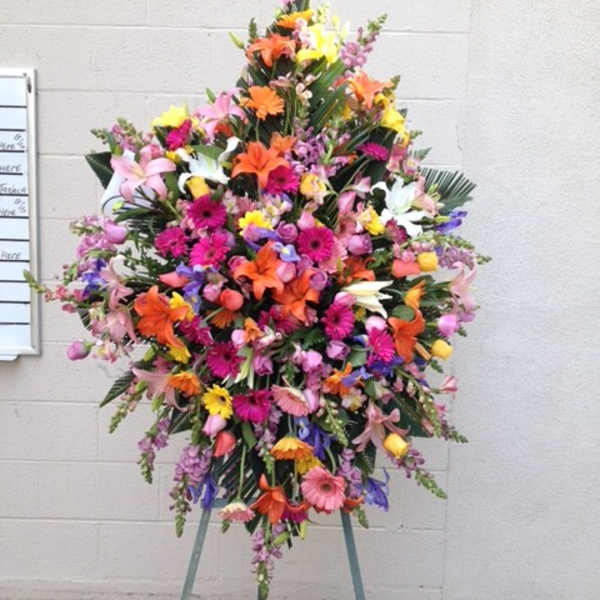 Large standing spray of mixed colorful flowers on an easel