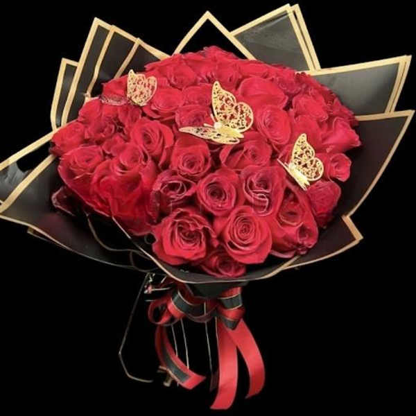 Bouquet of red roses wrapped in black paper with gold trim