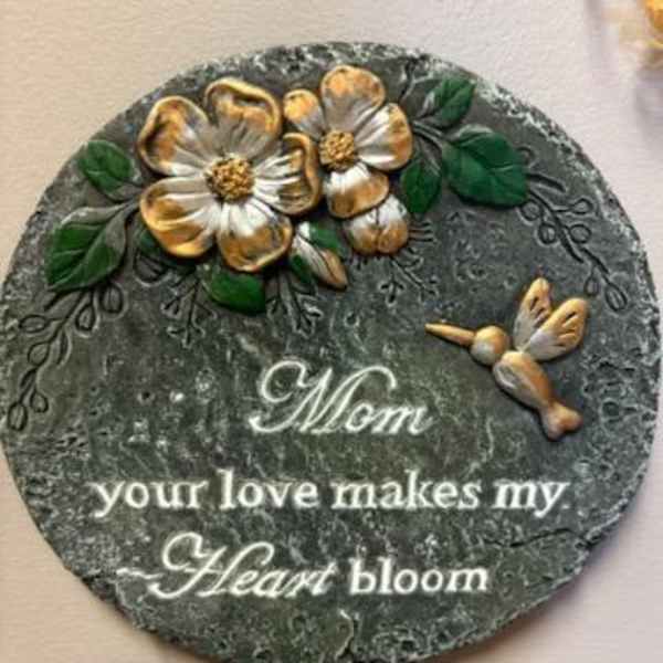 Round decorative plaque with gold flowers and the words "Mom your love makes my Heart bloom"