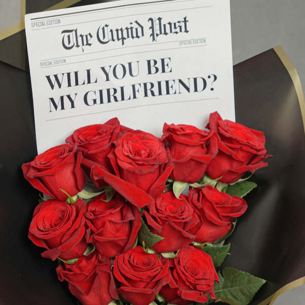 Bouquet of red roses with a newspaper-style proposal card