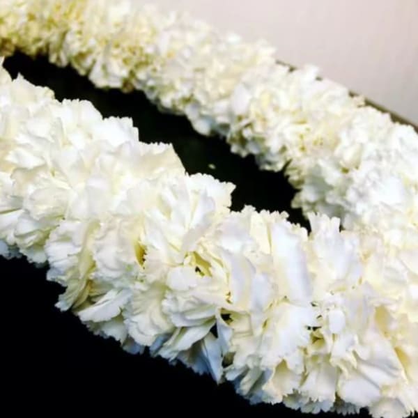 White floral lei on a dark surface