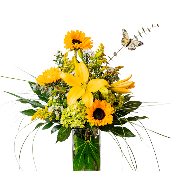 Yellow lilies and sunflowers in a clear glass vase