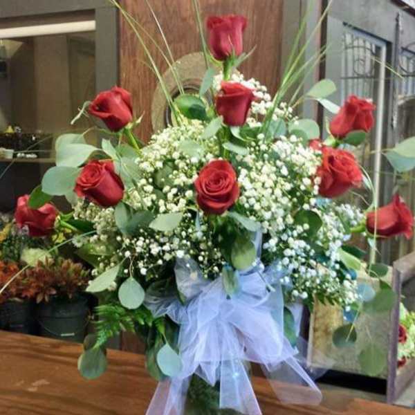 Bouquet of red roses with baby's breath in a glass vase