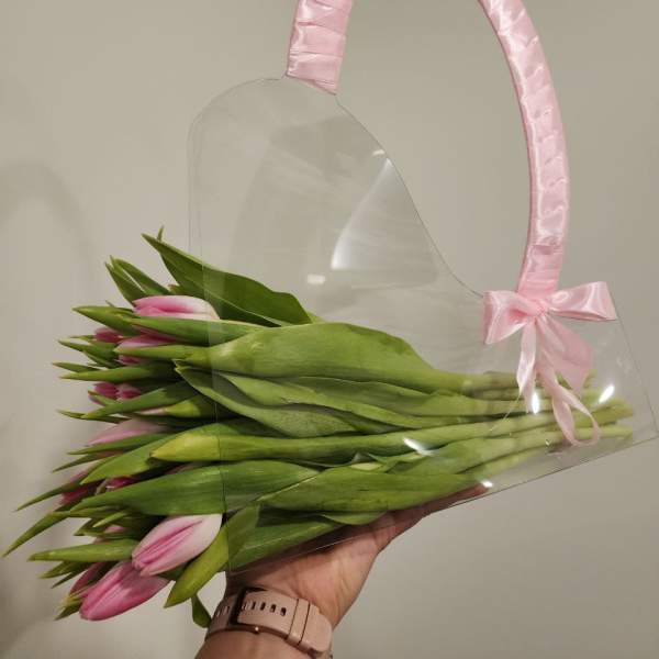 Pink tulips in a clear gift bag with a pink ribbon handle