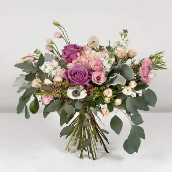 Bouquet of pink and purple roses with white blooms and eucalyptus