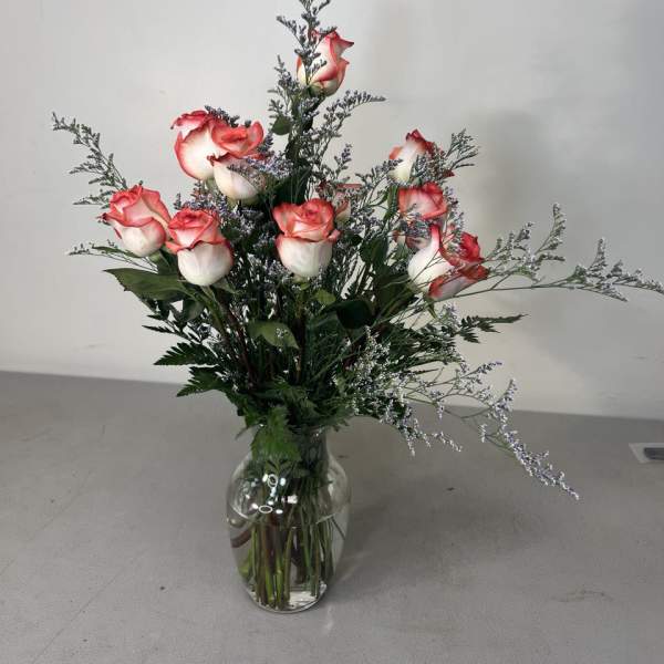 Pink-edged white roses arranged in a clear glass vase