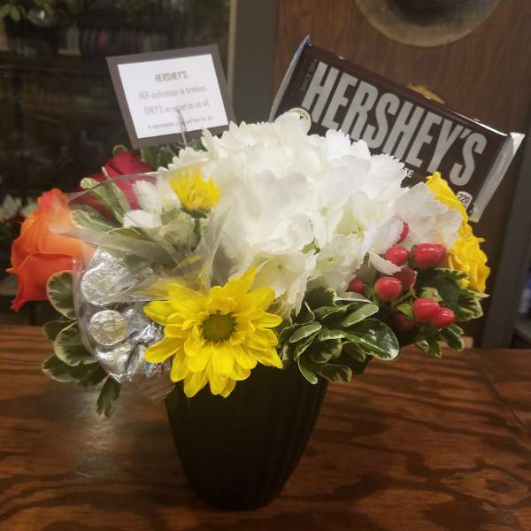 Bouquet of mixed flowers with a Hershey's chocolate bar in a black vase