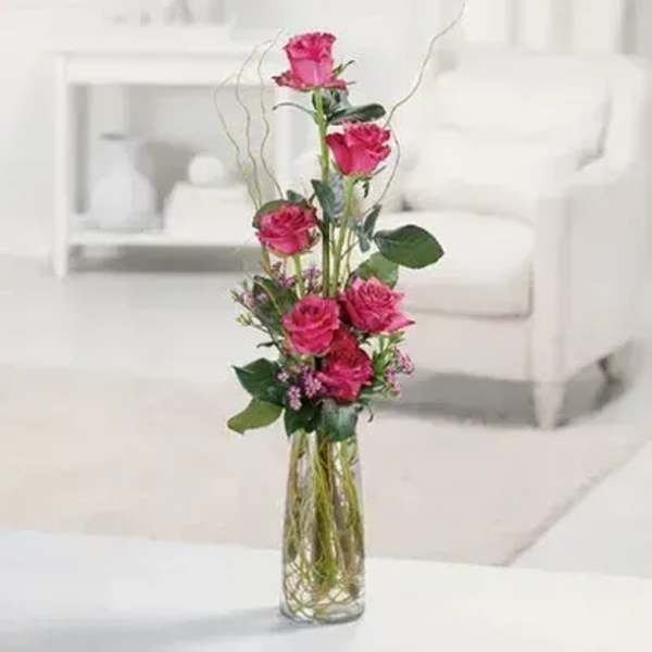 Tall pink rose arrangement in a clear glass vase