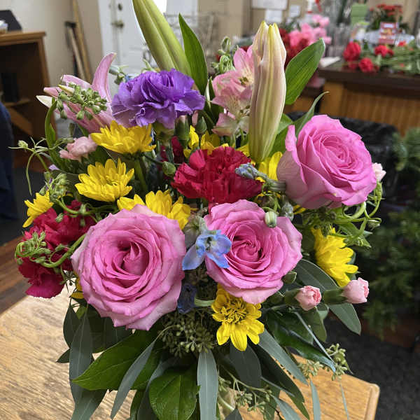 Mixed bouquet with pink roses, yellow daisies, and lilies