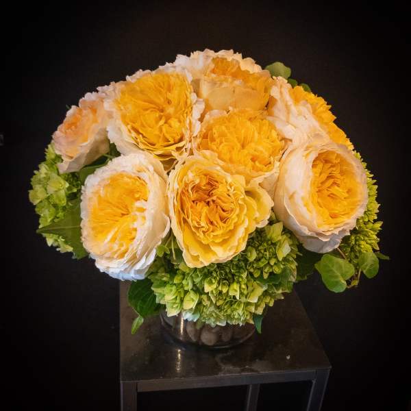 Yellow and white roses arranged in a glass vase