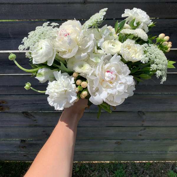 White bouquet of peonies, ranunculus, and carnations with laceflower accents