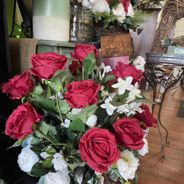 Red and white rose arrangement in a tall white vase