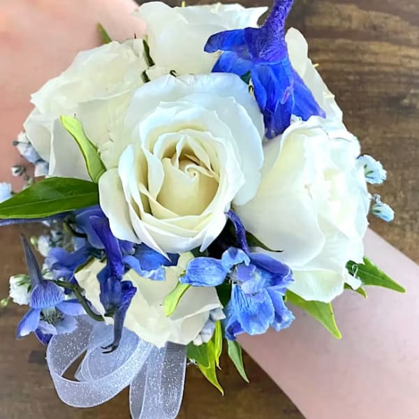White rose bouquet with blue flowers and a silver ribbon