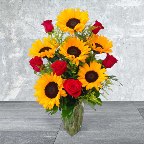 Bouquet of sunflowers and red roses in a clear glass vase