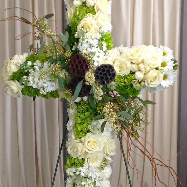 Large floral cross with white roses, daisies, and green hydrangeas