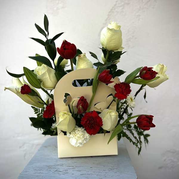 Red and white tulips with carnations in a cream gift bag